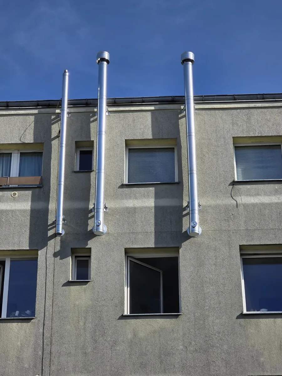 Kilka zewnętrznych systemów kominowych zamontowanych na elewacji
